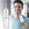 A man is smiling and using a portable water flosser on his teeth. Náhľad obrázku produktu