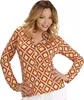 A woman is posing in a studio setting wearing a patterned blouse. Produktbild-Vorschau