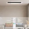 A modern LED ceiling light is shown mounted on a ceiling above a living room sofa, with a remote control in the foreground displaying its functions. Voir les images du produit