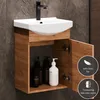 A bathroom vanity with a sink and cabinet, featuring bottles of soap or lotion inside the open cabinet. Produktbild-Vorschau