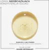 A close-up of a drop of golden hair oil with air bubbles, against a white background. Text describes the product's consistency and usage. Podgląd zdjęcia produktu