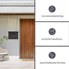 A black mailbox mounted on a light-colored wall next to a wooden door, with decorative text and icons on the right side of the image. Voir les images du produit