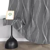 A close-up view of a dark gray curtain with a white wavy line pattern, draped over a small table with a framed picture on it. Produktbild-Vorschau