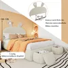 A child's bed with a rabbit-themed headboard, decorated with pillows and a blanket. Storage ottomans are placed at the foot of the bed. Anteprima dell’immagine prodotto