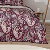 A close-up view of a burgundy paisley patterned comforter on a bed. Produktbild-Vorschau