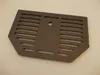 A dark gray metal grate with horizontal slots and a central circular hole, lying flat on a light gray surface. Anteprima dell’immagine prodotto