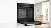 An open built-in oven in a modern kitchen setting. Produktbild-Vorschau