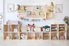 A children's room with wooden shelves filled with toys and books. Produktbild-Vorschau