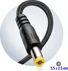 Close-up of a black power adapter connector with a yellow insert, set against a light gray and white circular background. Voir les images du produit