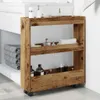 A narrow, three-tier storage cart with a rustic wood-look finish is shown in a bathroom setting next to a sink and stacked towels. Podgląd zdjęcia produktu