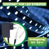 A close-up view of an LED strip light power adapter and extension cable, with a blurred background of illuminated LED strips. Náhled obrázku produktu