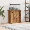 An aquarium stand with an aquarium on top, placed in a room with a plant and a bookshelf in the background. Produktbild-Vorschau