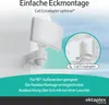 A white outdoor light fixture with a motion sensor is mounted on a white wall, with a close-up inset showing an optional corner mounting adapter. Produktbild-Vorschau