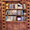 A miniature bookshelf filled with books and decorative items, presented as a DIY kit. Voir les images du produit