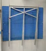 A blue pegboard wall with a silver metal sawhorse attached. Produktbild-Vorschau