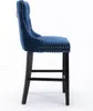 A side view of a blue velvet bar stool with tufted back and nailhead trim. Produktbild-Vorschau