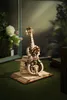 A wooden model of a cello with intricate gears and mechanical details, placed on top of books. Voir les images du produit