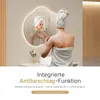 A woman in a towel is looking in a bathroom mirror. Podgląd zdjęcia produktu