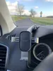 View from inside a car, looking out at a road and landscape. A car phone mount is attached to the dashboard. Anteprima dell’immagine prodotto