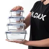 A person is holding a stack of four glass food storage containers. Anteprima dell’immagine prodotto