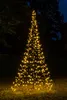 A lit-up Christmas tree decoration in a yard at night. Produktbild-Vorschau
