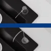 Close-up view of a black kitchen sink with a transparent hose and suction cup. Produktbild-Vorschau