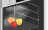 Three bell peppers being steamed inside an oven. Anteprima dell’immagine prodotto