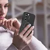 A woman is holding a smartphone with a black protective case. Produktbild-Vorschau