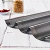 A close-up shot of a perforated baguette baking pan on a white wooden surface. Anteprima dell’immagine prodotto