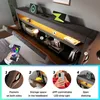 A bed with a headboard featuring storage, lighting, and charging capabilities, shown with a smartphone controlling the lights. Produktbild-Vorschau