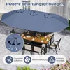 An outdoor dining set with a large blue umbrella, set on a paved patio with plants in the background. Náhľad obrázku produktu