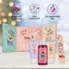 A collection of holiday-themed advent calendars and small cosmetic products arranged on a wooden surface with a blurred background of festive lights. Produktbild-Vorschau