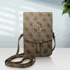A Guess handbag with a monogram pattern and a gold logo is displayed on a white surface with a blurred background. Podgląd zdjęcia produktu