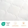 A close-up of quilted white fabric with certification logos and text at the bottom. Produktbild-Vorschau