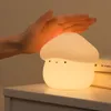 A hand is touching a mushroom-shaped night light on a nightstand. Podgląd zdjęcia produktu