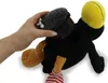 A hand is holding a black device with holes over a stuffed black raven toy with a yellow head and orange feet. Produktbild-Vorschau