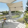 A balcony with a chair, table, and umbrella overlooking a river and trees. Produktbild-Vorschau
