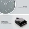 A split image showing the top half of a minimalist wall clock and the bottom half showing a battery-powered clock mechanism. Náhled obrázku produktu