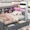 A grey wooden daybed with storage drawers and a headboard featuring shelves and LED lighting. The bed is made with star-patterned bedding and a pink throw blanket. Produktbild-Vorschau
