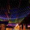 A street decorated with colorful net lights at night. Voir les images du produit