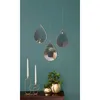Three teardrop-shaped mirrors with gold frames hang on a teal wall above a dark wood dresser. On the dresser, a gold candelabra holds two white candles, and two gold planters hold green plants. Produktbild-Vorschau