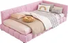 A pink upholstered corner bed with multiple pillows and blankets. Náhled obrázku produktu