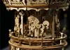 A close-up view of a wooden carousel model, focusing on a carved horse. Anteprima dell’immagine prodotto