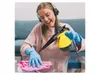 A woman wearing headphones is cleaning a glass surface with a steam cleaner and a pink cloth. Anteprima dell’immagine prodotto