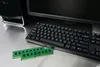 A computer monitor, keyboard, and two RAM modules are displayed on a reflective surface. Podgląd zdjęcia produktu