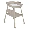 A beige baby changing table with a white changing mat and storage pockets, shown on a white background. Náhľad obrázku produktu