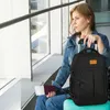 A woman sits in an airport terminal with her luggage. Produktbild-Vorschau