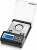A digital milligram scale with its protective cover open. Voir les images du produit