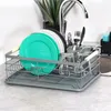 A dish drying rack filled with plates, glasses, and utensils next to a kitchen sink. Produktbild-Vorschau