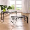 Two black metal plant stands are placed on a wooden floor in front of large windows with white curtains. Produktbild-Vorschau